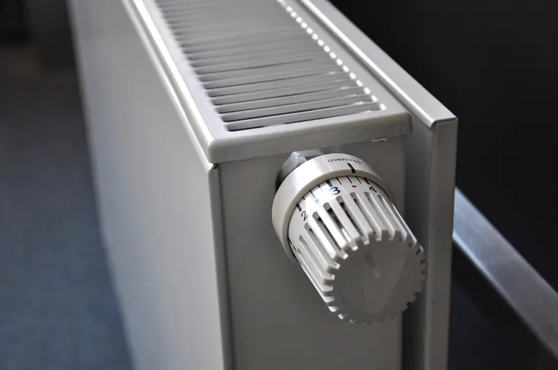 Een witte paneelradiator met een thermostatische kraan