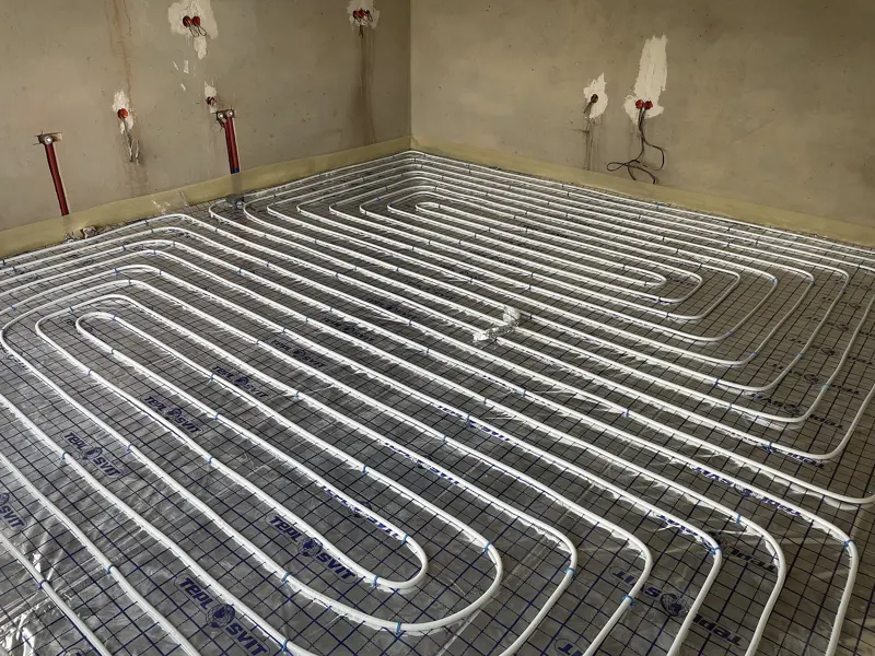 Buizen van vloerverwarming in lussen op een wapeningsnet